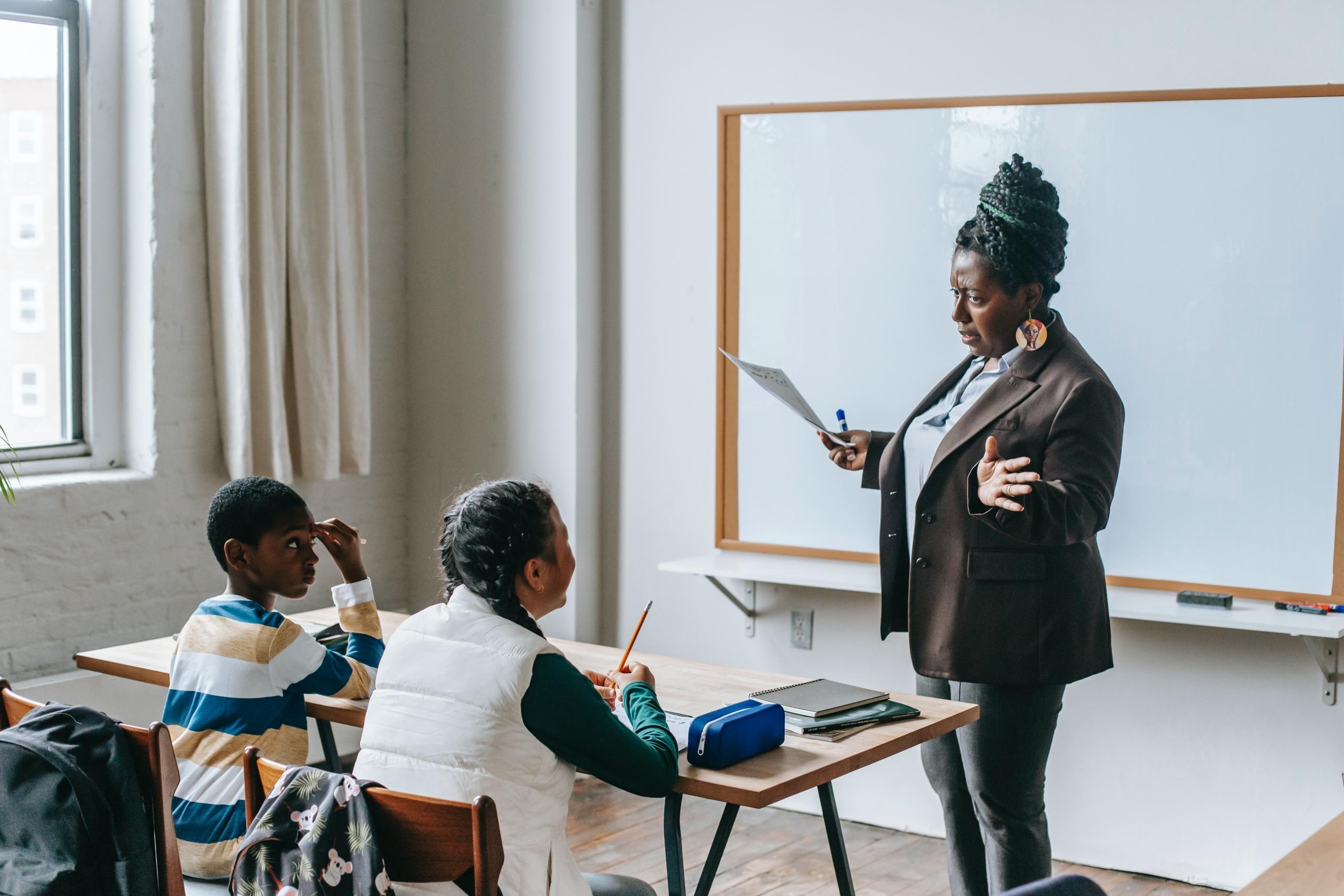 Black teacher and two kids