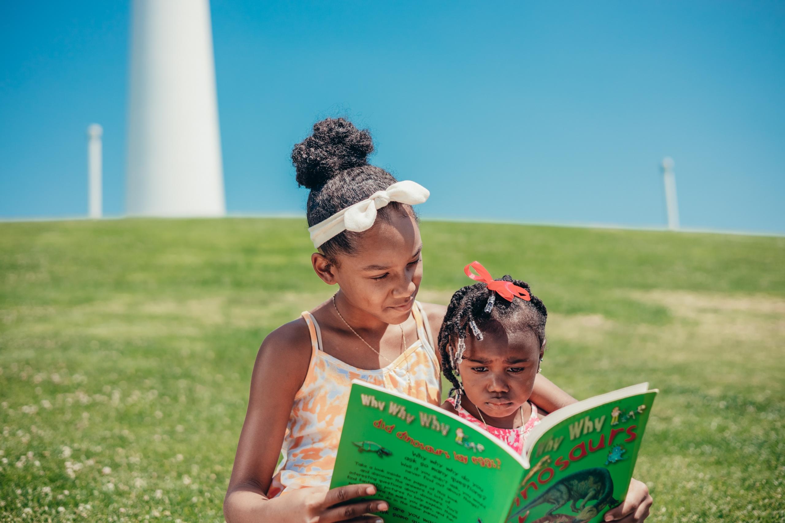 Girl teaching her younger sister to read