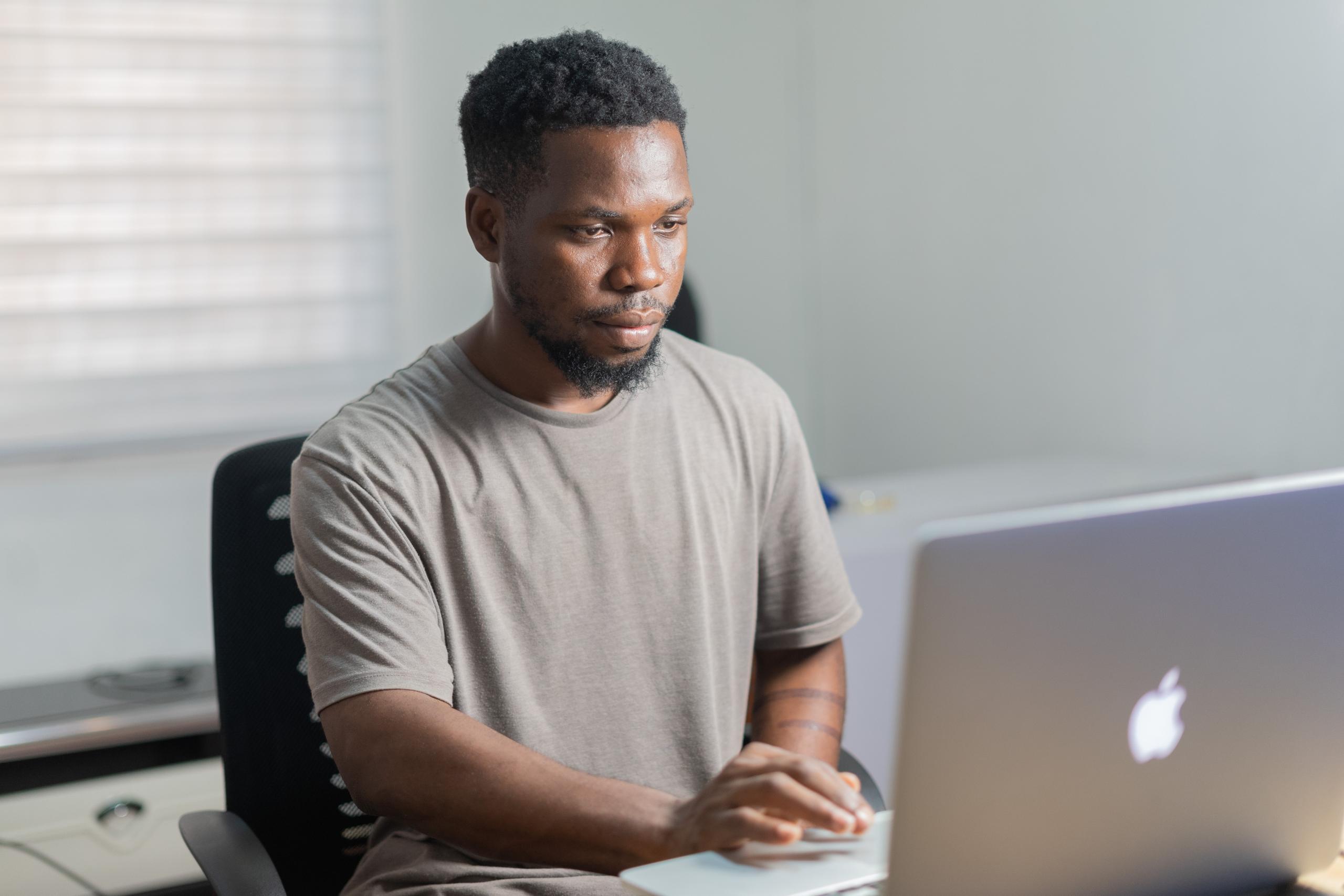 Black man working with a MacBook