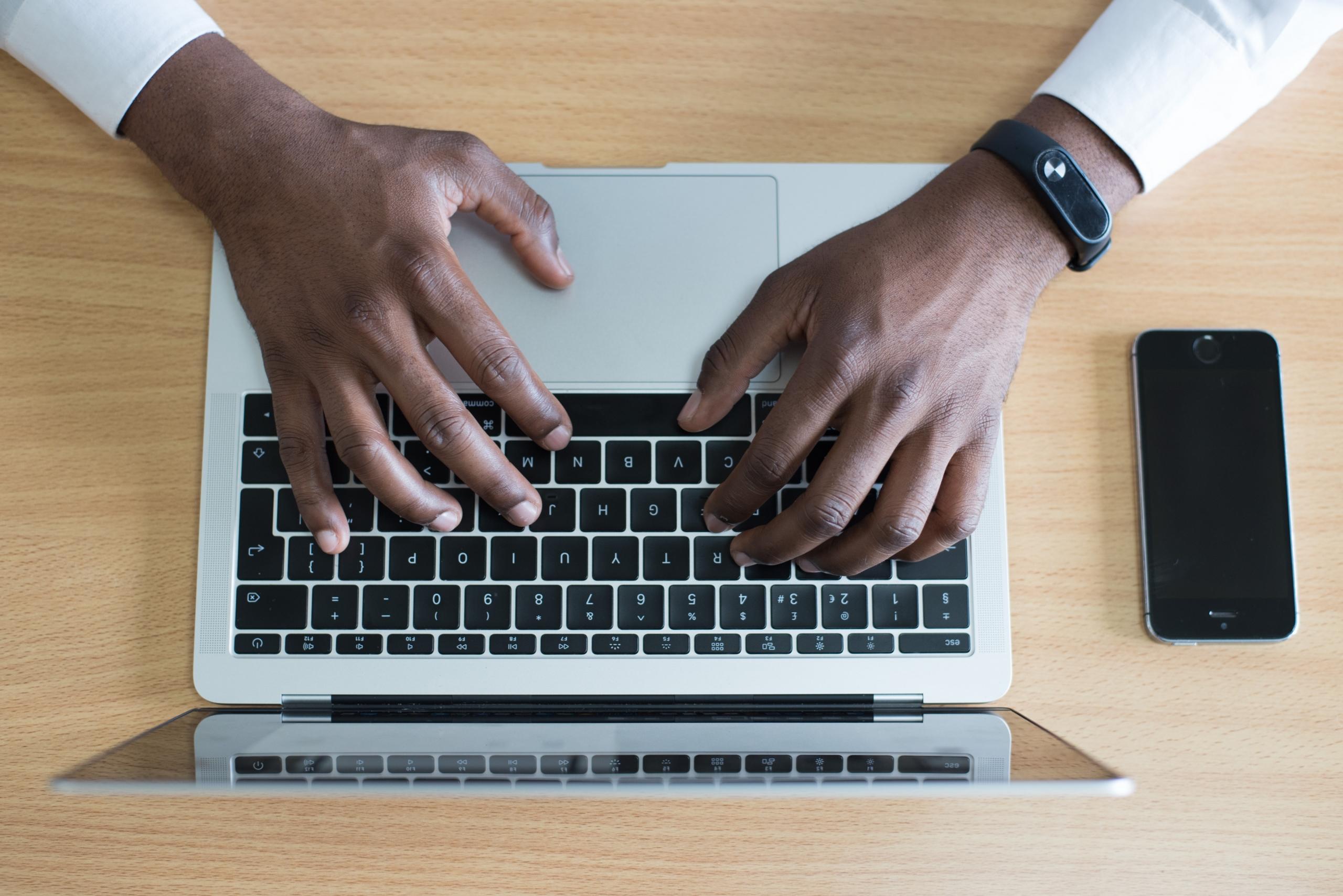 A man's hands on a laptop