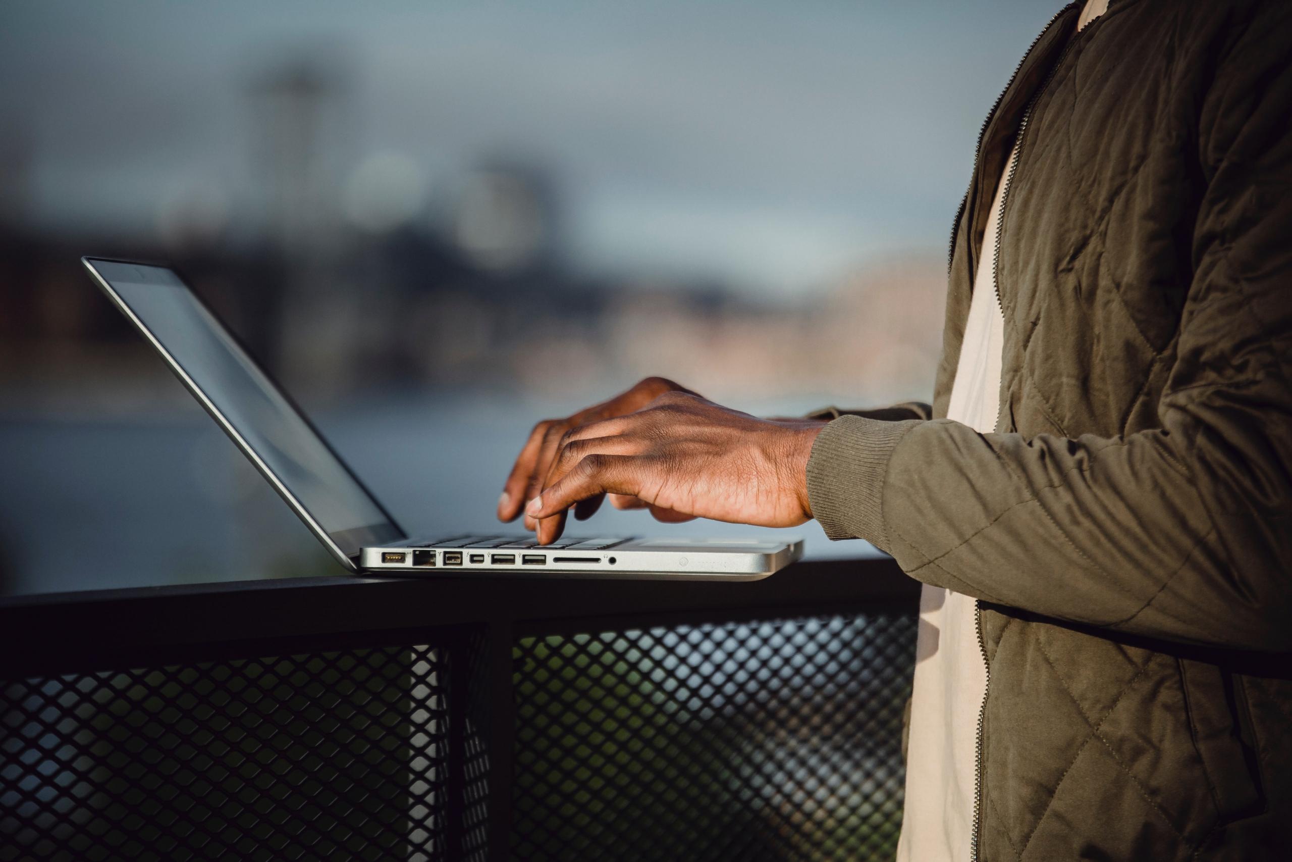 A man typing on a laptop