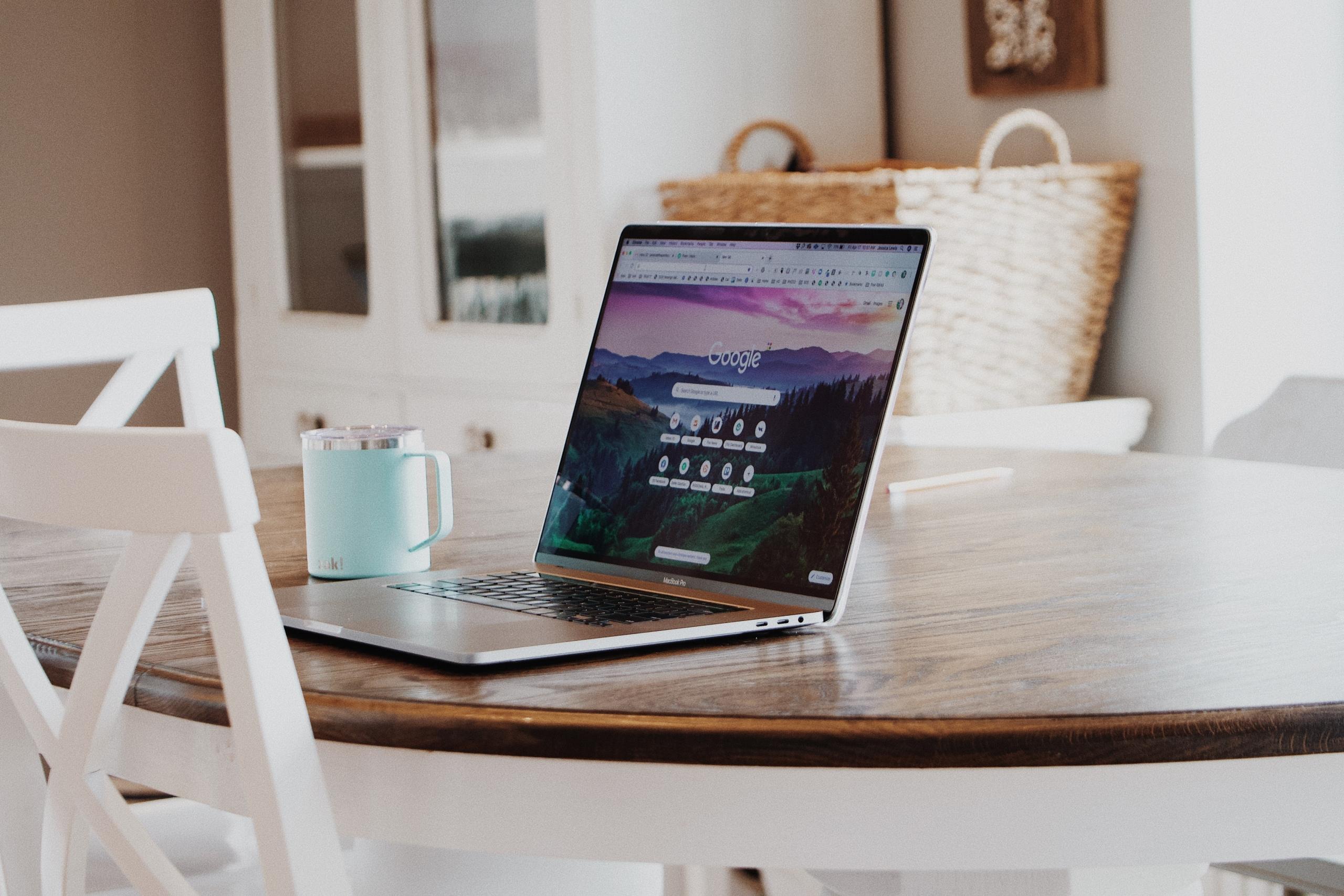 A laptop and mug on a table