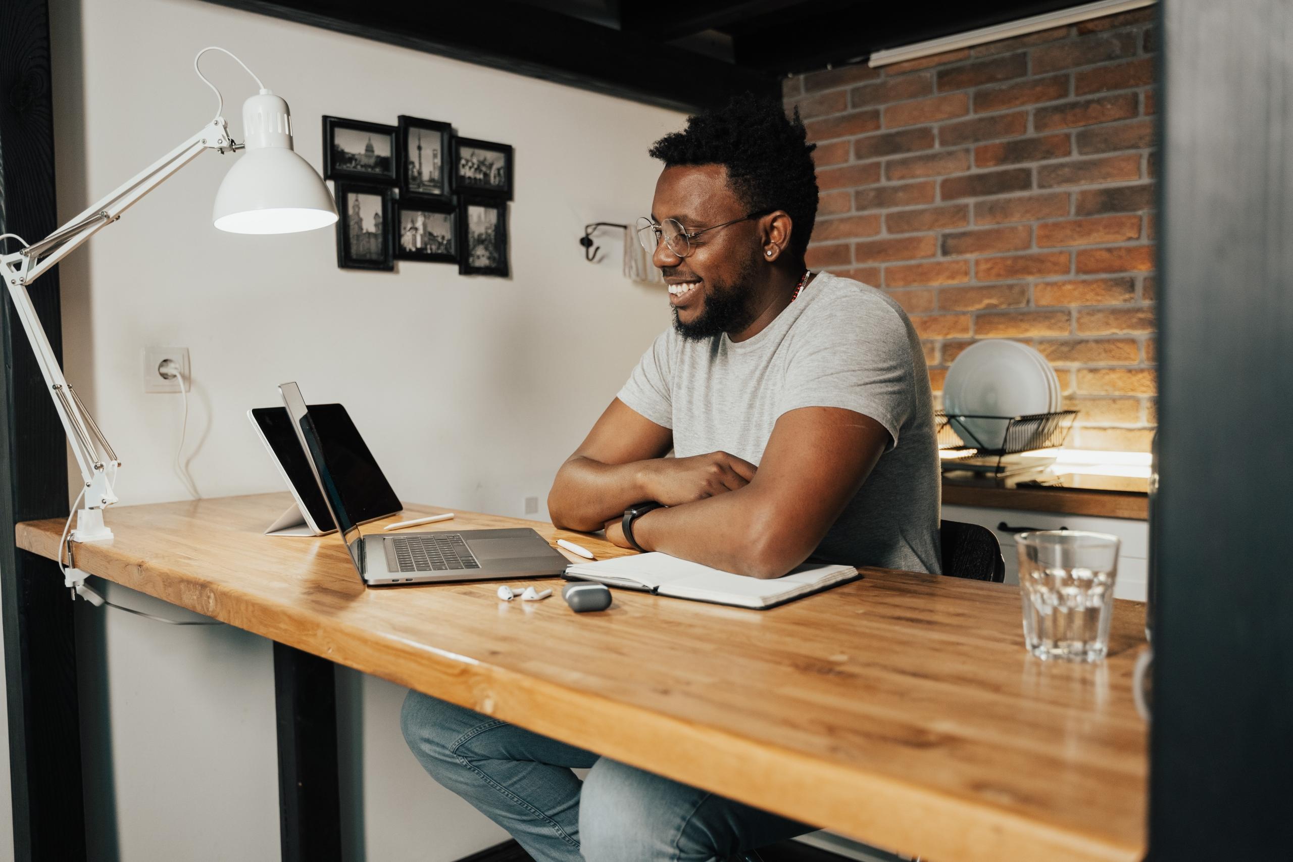 A man smiling at a laptop