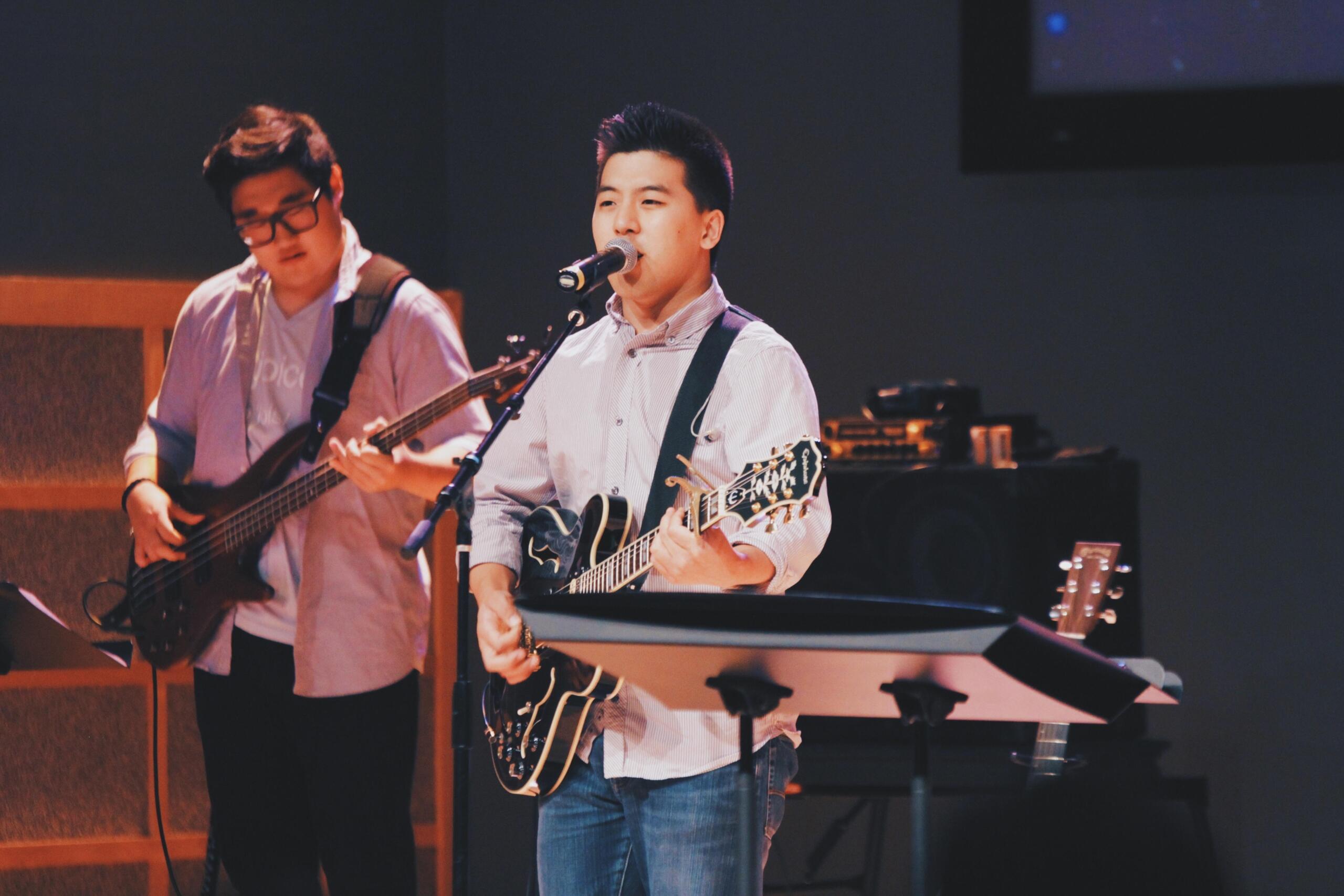 Two young men performing with guitars on stage