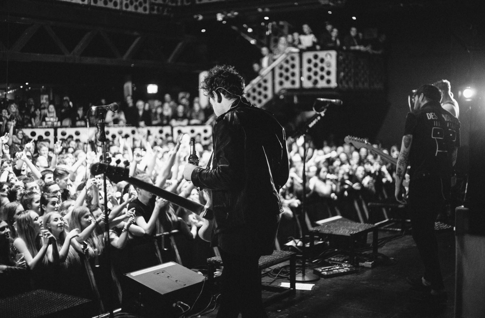 A rockstar guitarist plays guitar in front of an audience