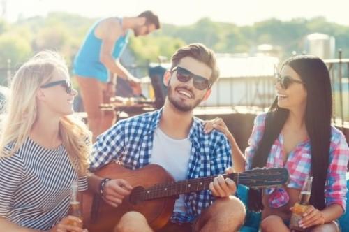 A man playing the guitar between two women.