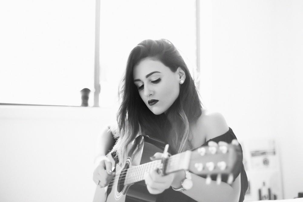 A woman plays the guitar.