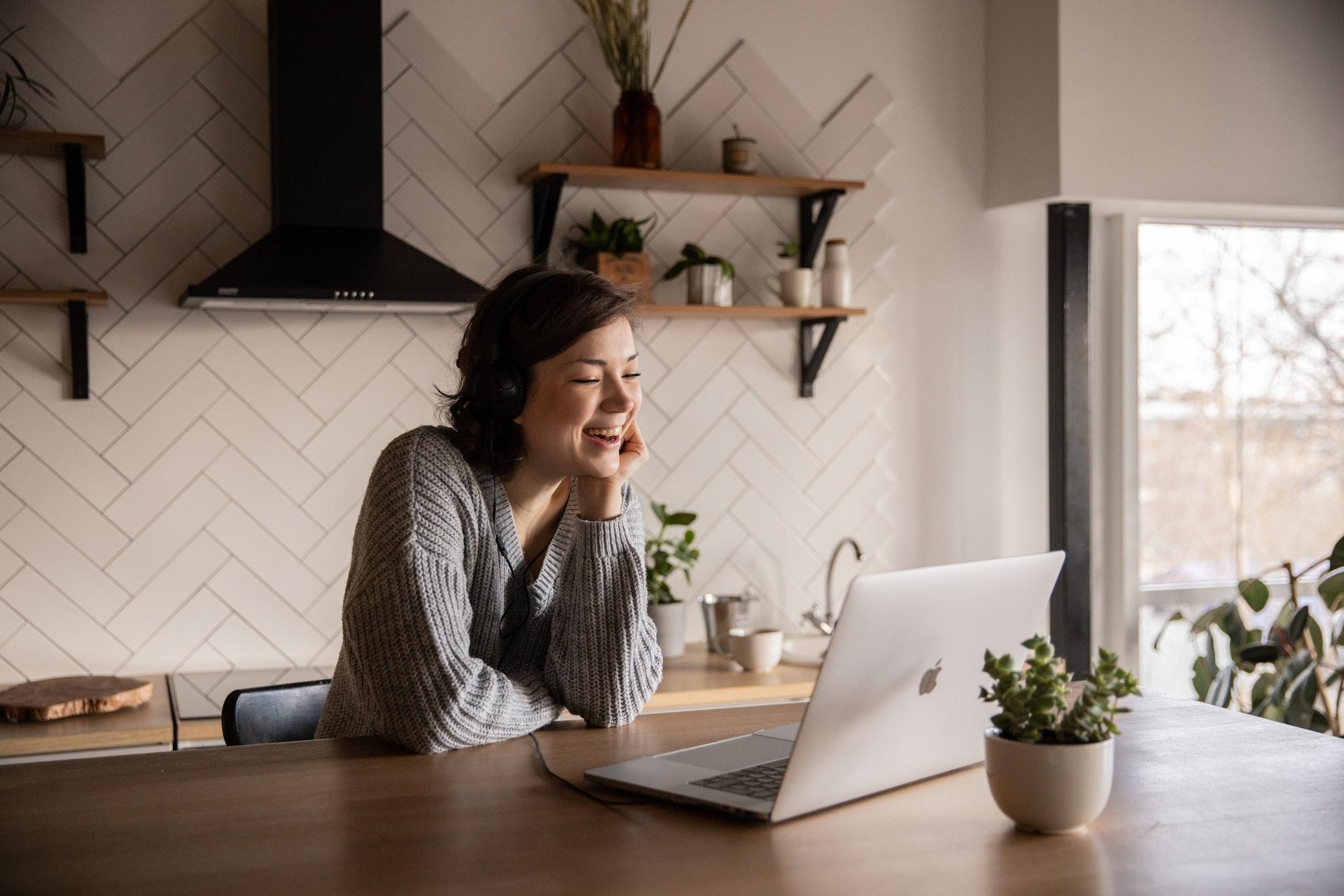 Vrouw geeft online lessen in haar keuken op een laptop