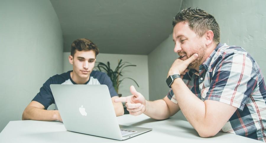 Leraar met leptop legt uit aan student