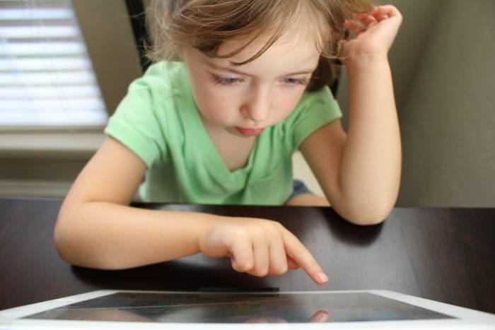 Kind wijst iets aan op tablet