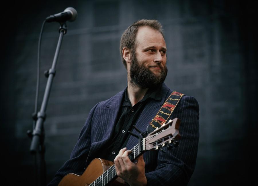 man speelt akoestische gitaar