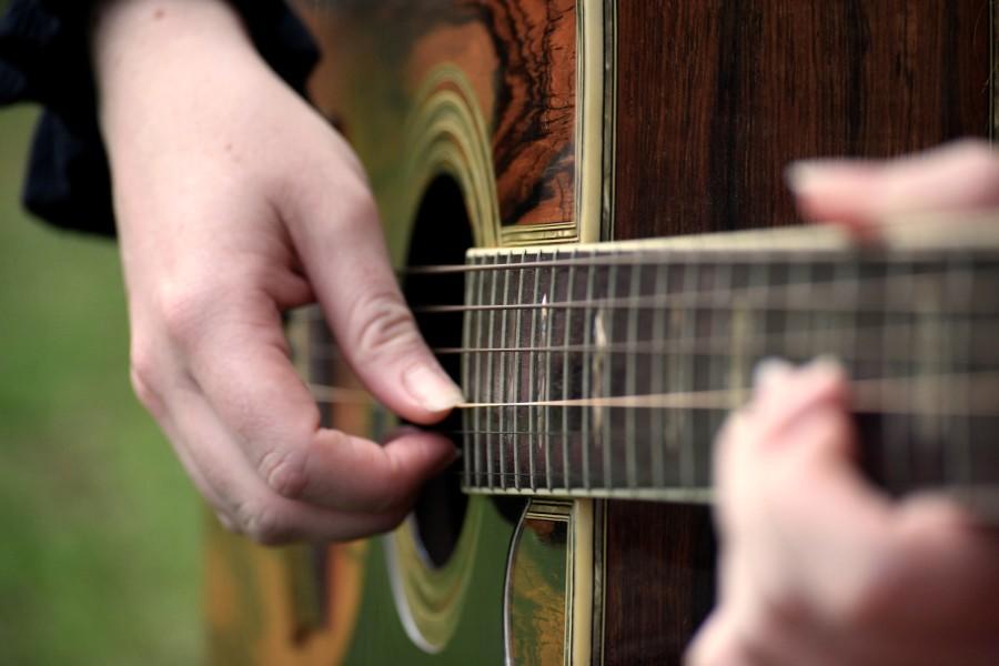 Gitaar close up met tokkelende hand