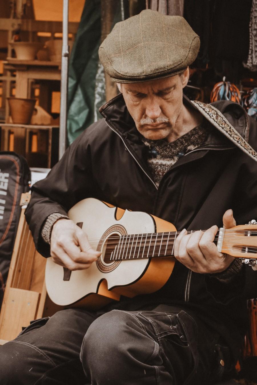man speelt op straat gitaar