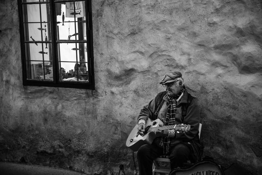 Oudere speelt gitaar in huis