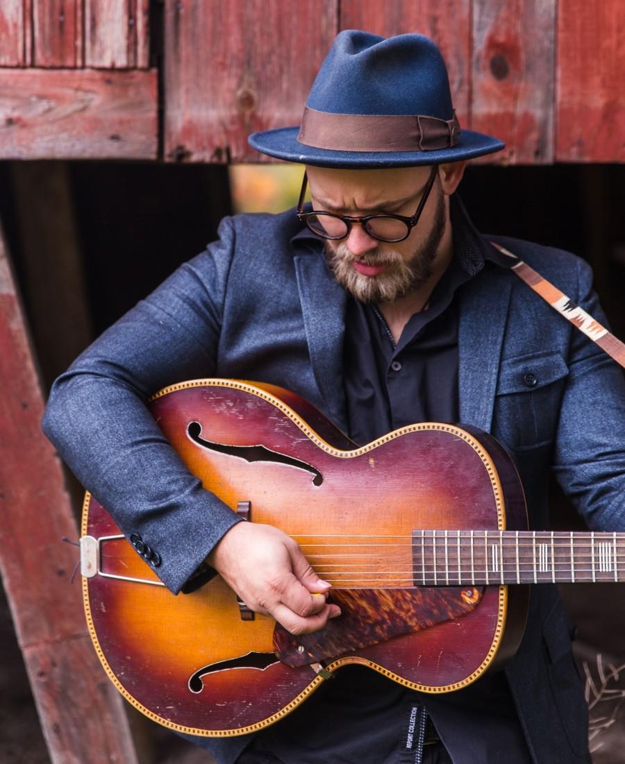 oudere man speelt op akoestische gitaar