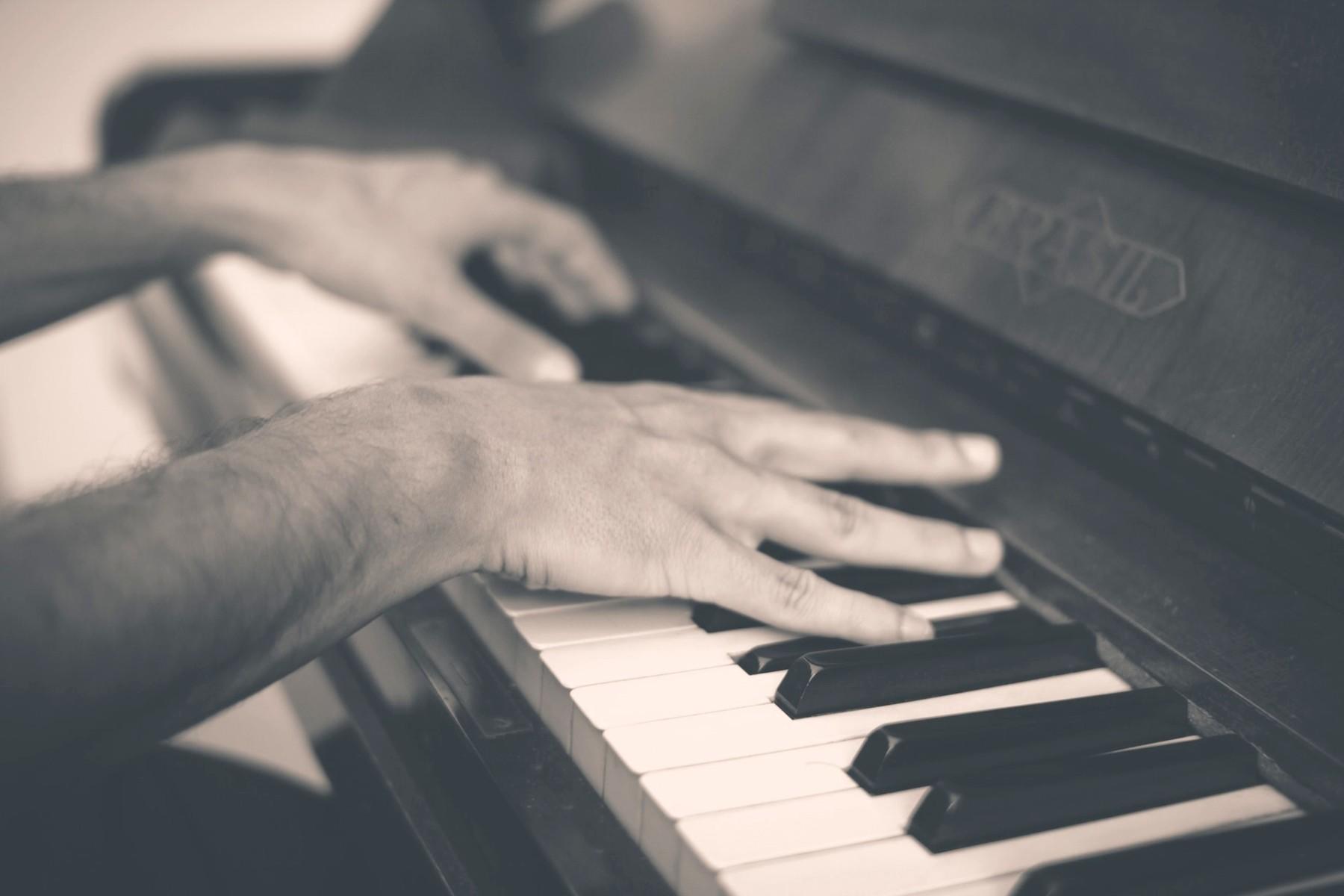 Zwart-wit foto handen die op de piano spelen