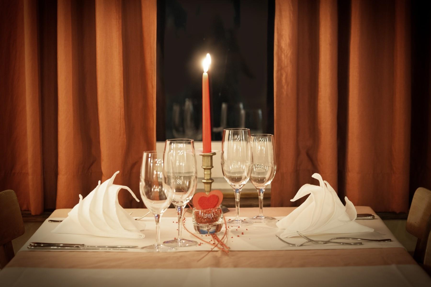 brandende kaars en wijnglazen op fraai opgemaakte tafel