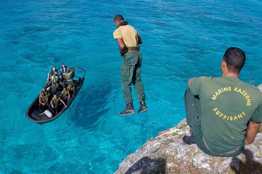 militair in opleiding springt van hoogte in het water