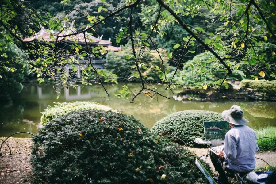 man schildert in Japanse tuin
