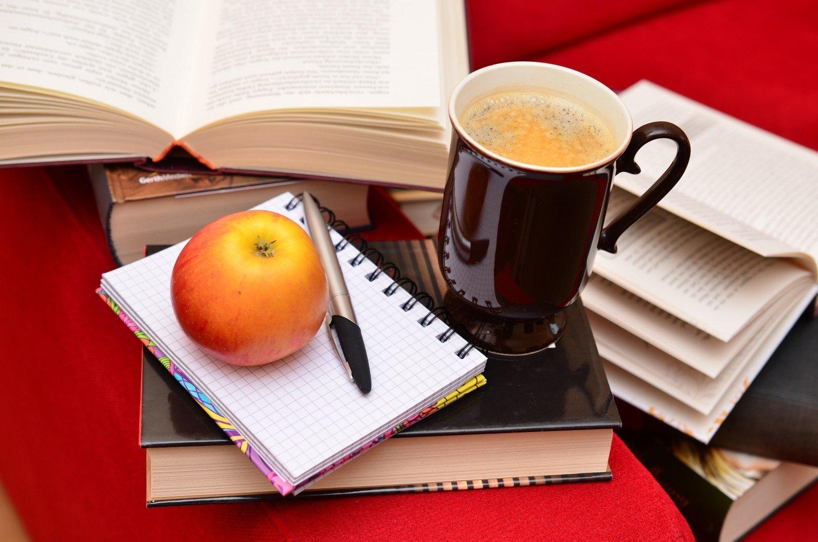 Boeken, pen en papier, appel en beker