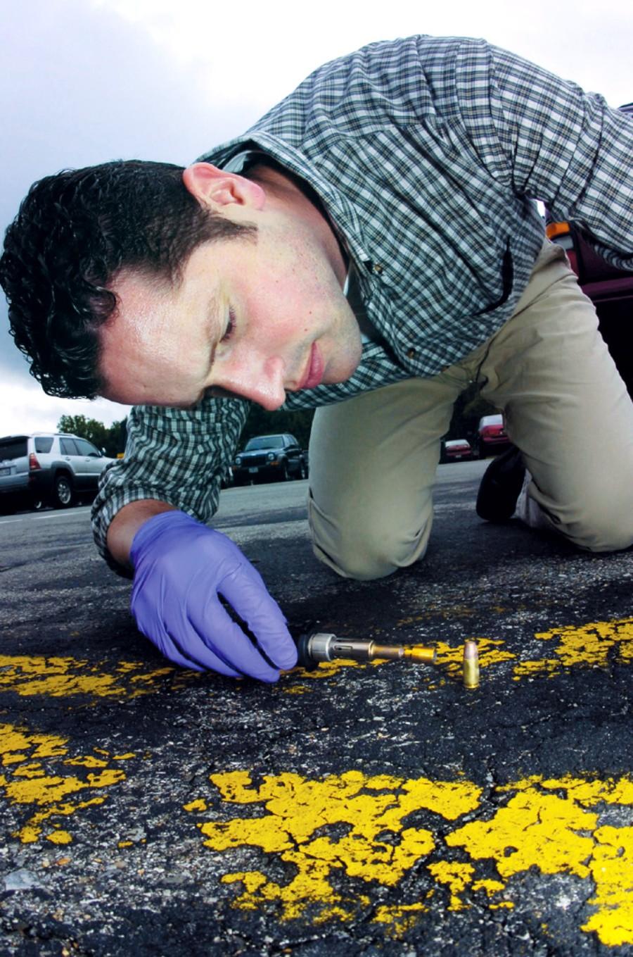 forensisch medewerker onderzoekt materiaal op straat