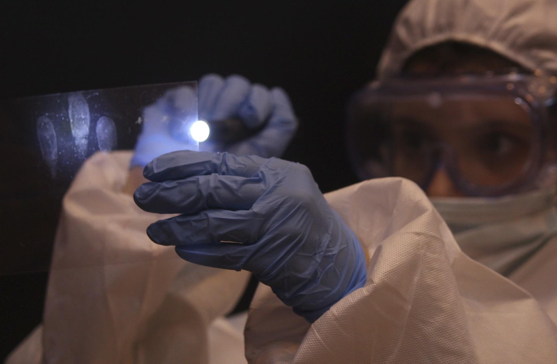 forensische onderzoeker prepareerd vingerafdrukken