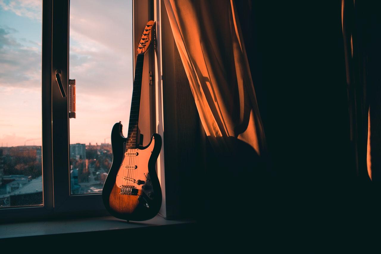Elektrische gitaar in een open raam.