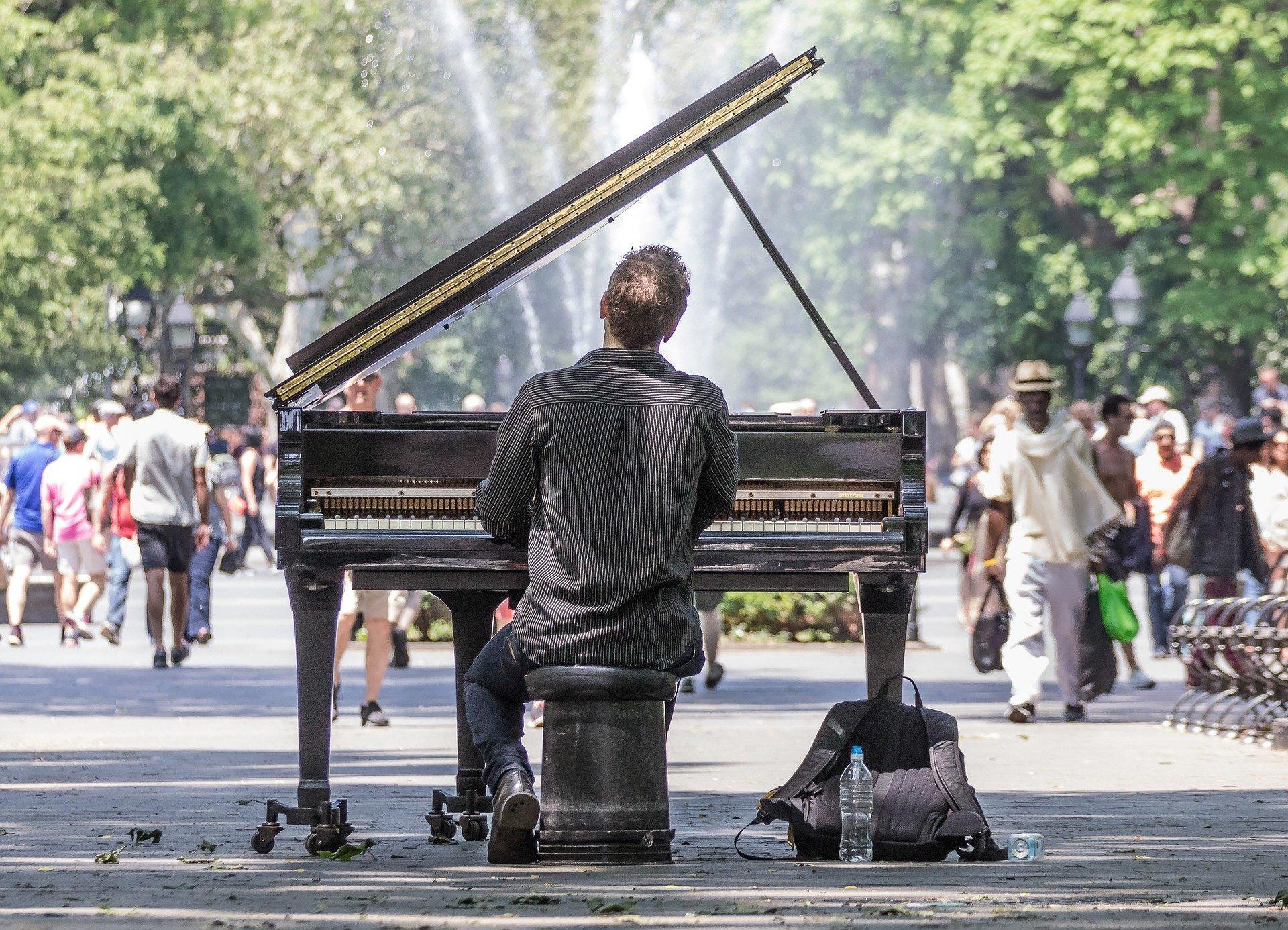 Een man die piano speelt in de buitenlucht.