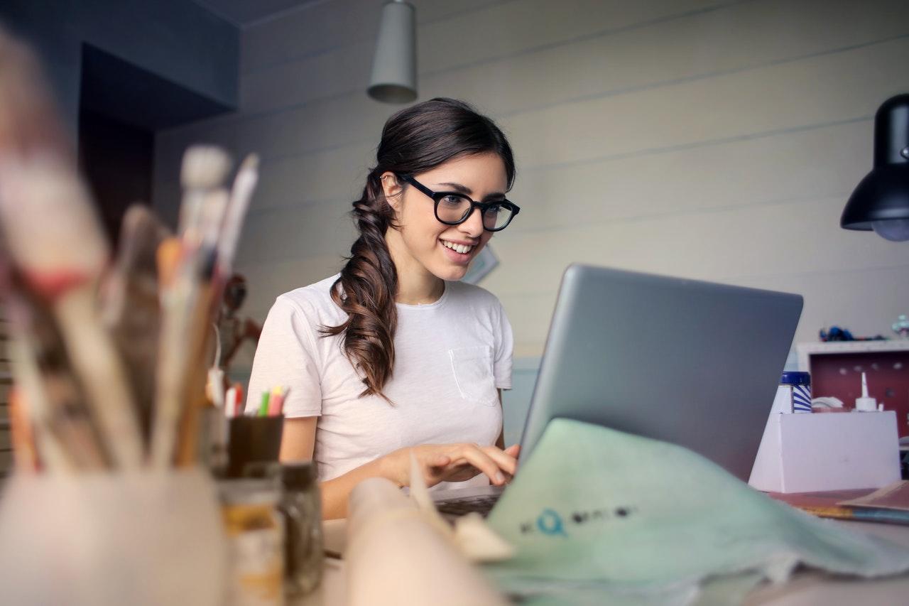Blije vrouw achter de laptop