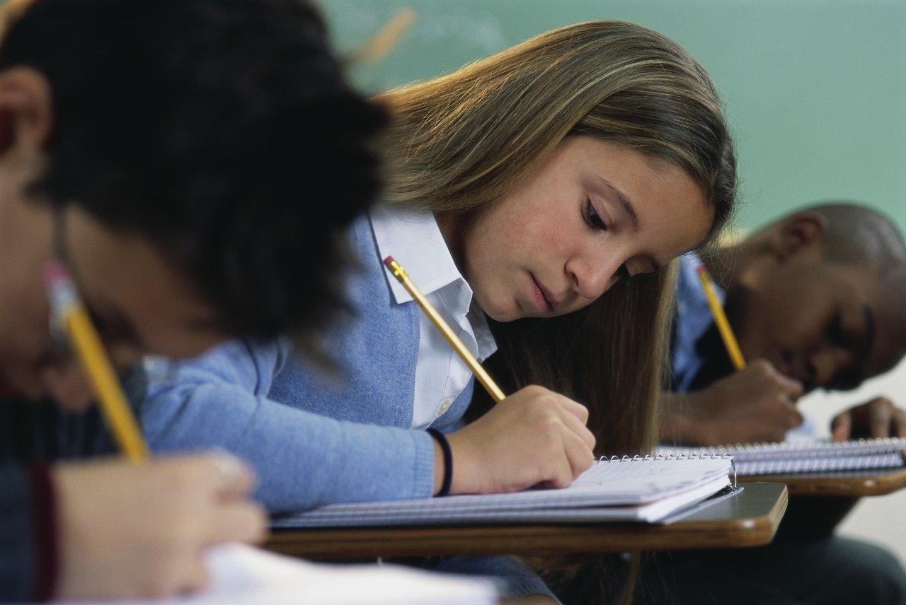 Student is ijverig huiswerk aan het maken in een klaslokaal