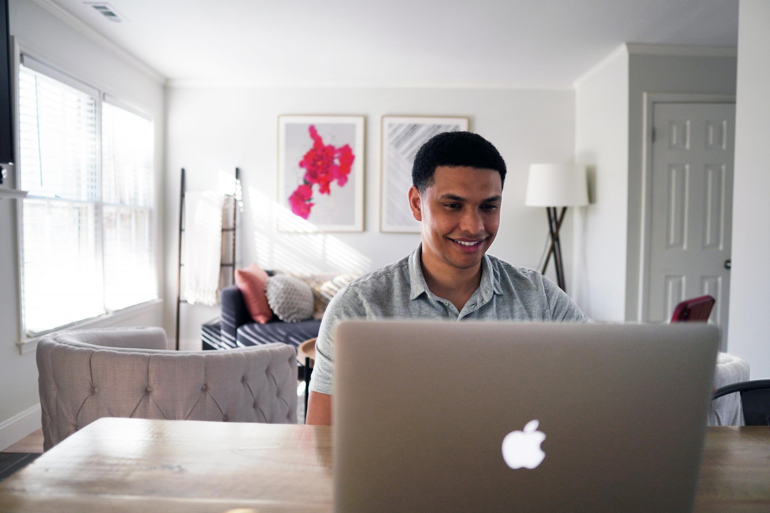Man achter laptop in huiskamer