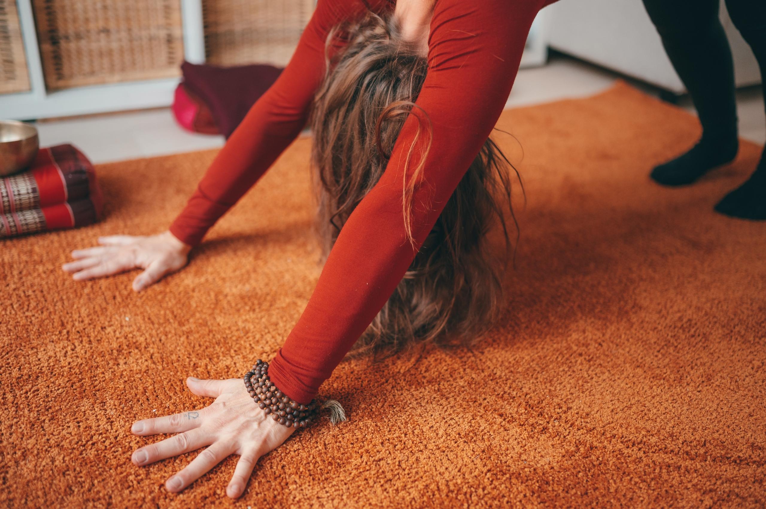 Een meisje doet de neerwaartse hond een essentiële pose in de yoga