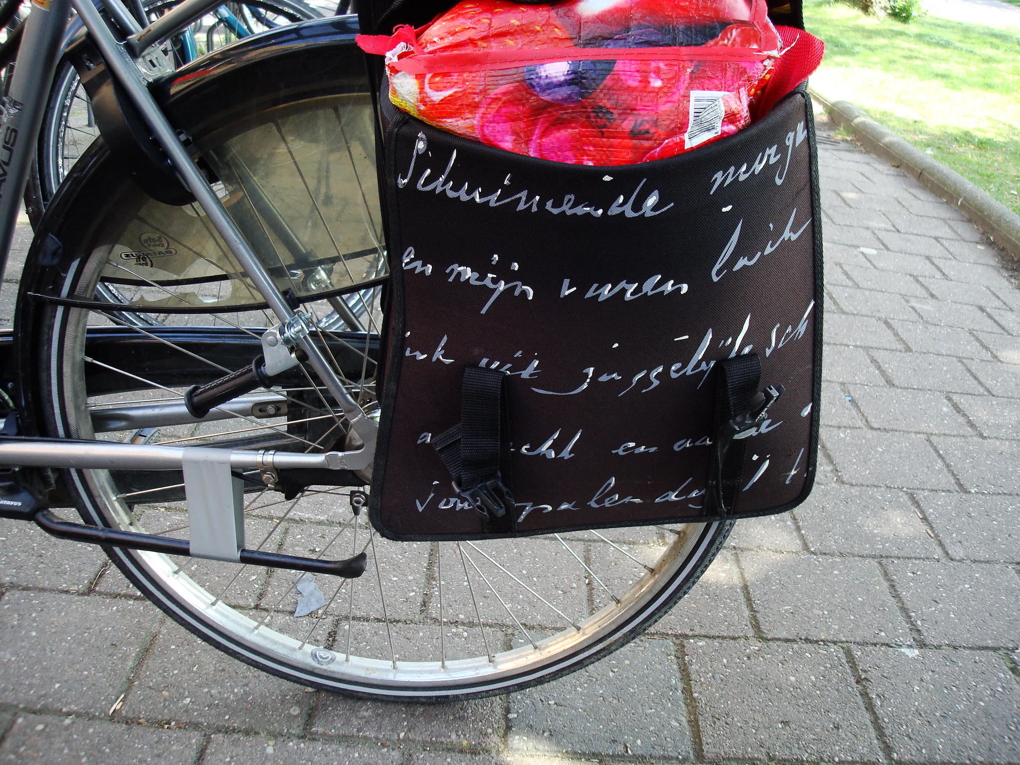 Een fiets met een fietstas met een gedicht van Hendrik Marsman erop