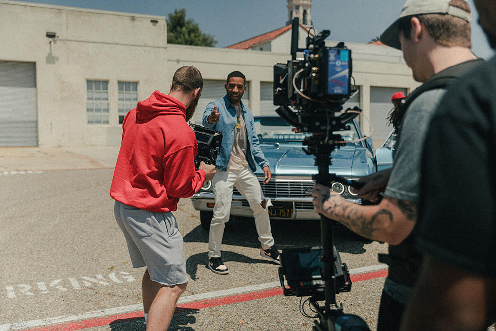 Een filmcrew maakt een opname van een acteur in een parkeerplaats