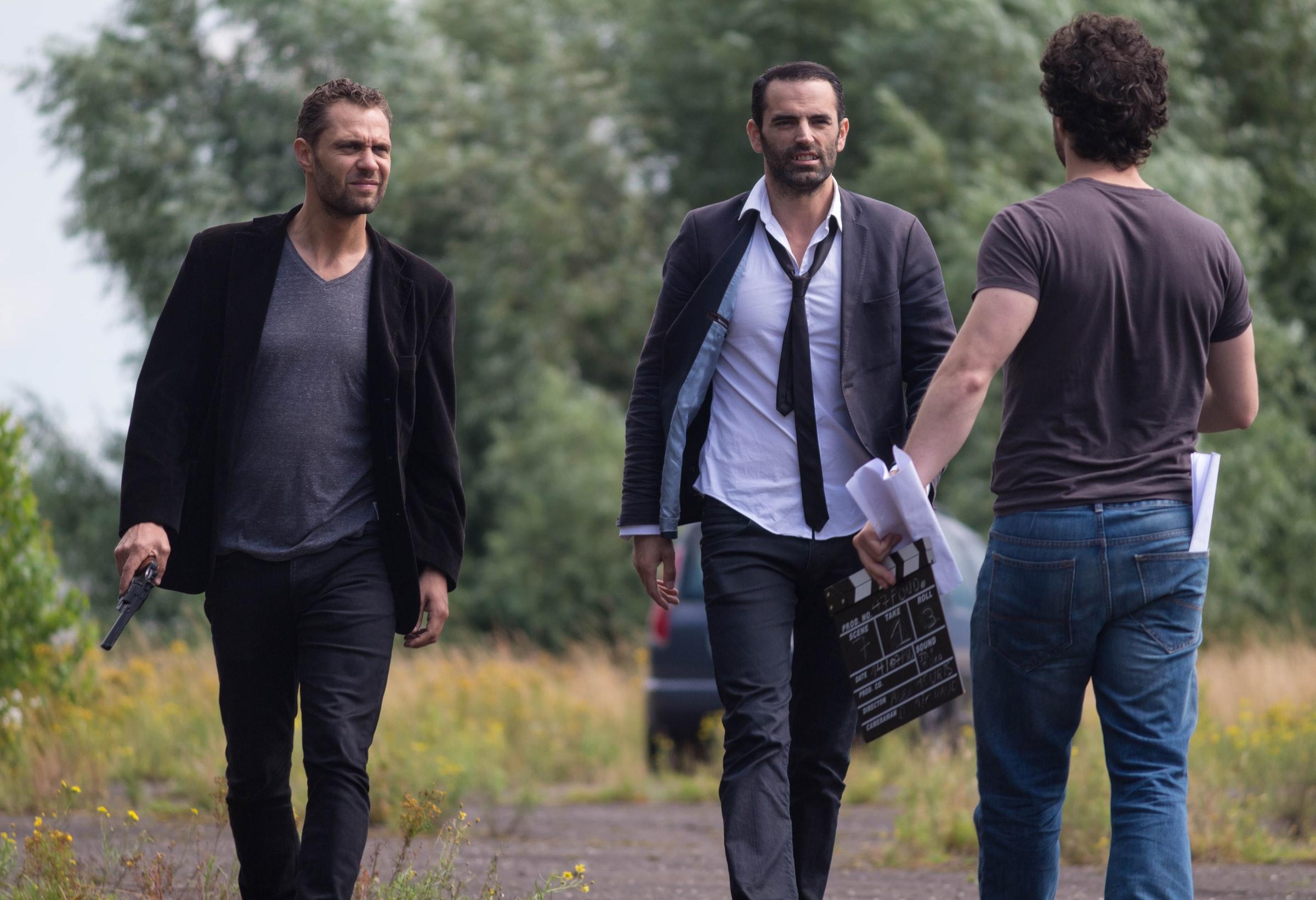 Take uit een film met drie mannen die op een bosweg elkaar ontmoeten