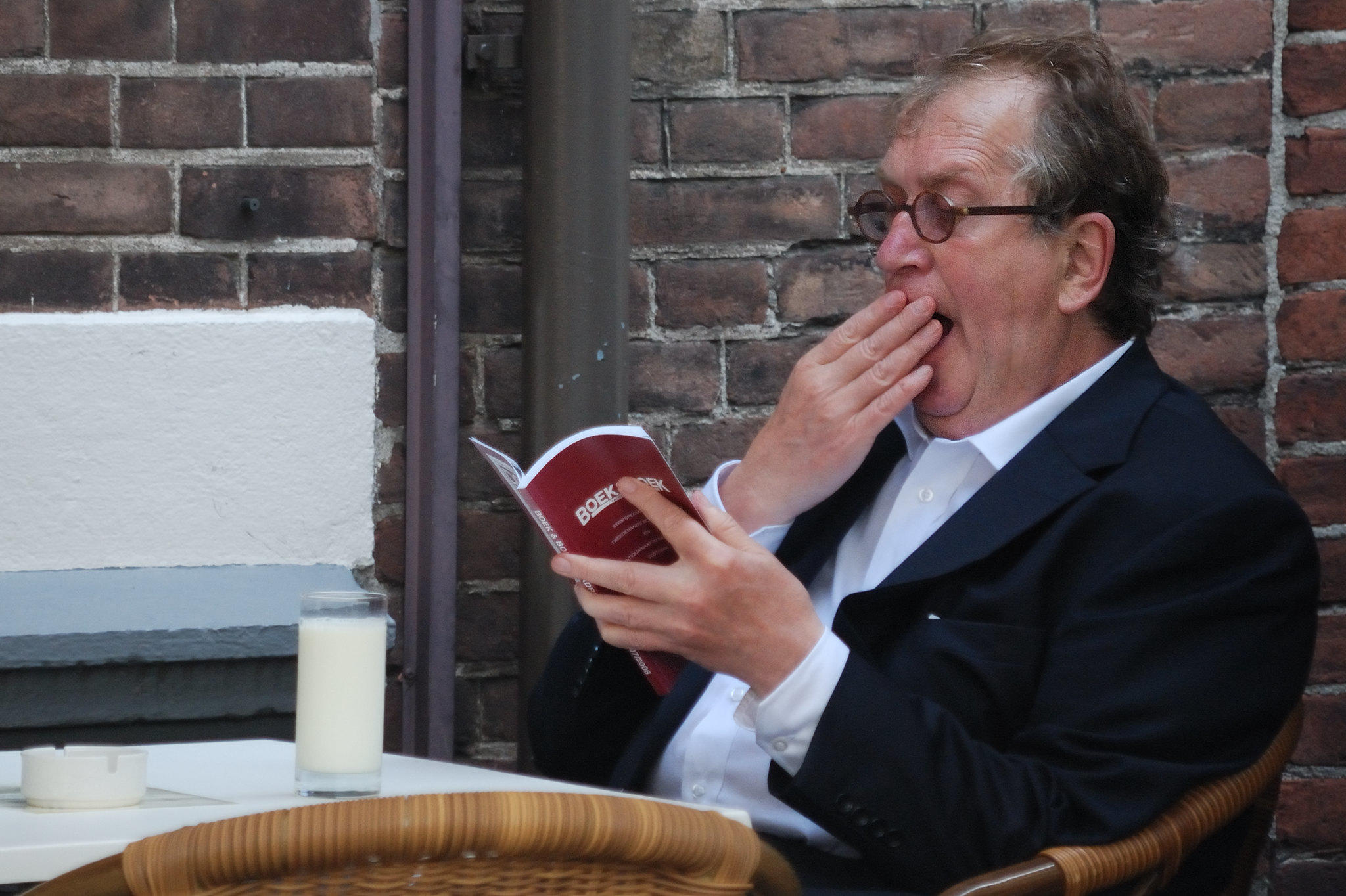 Komrij zittend op een terras en gapend