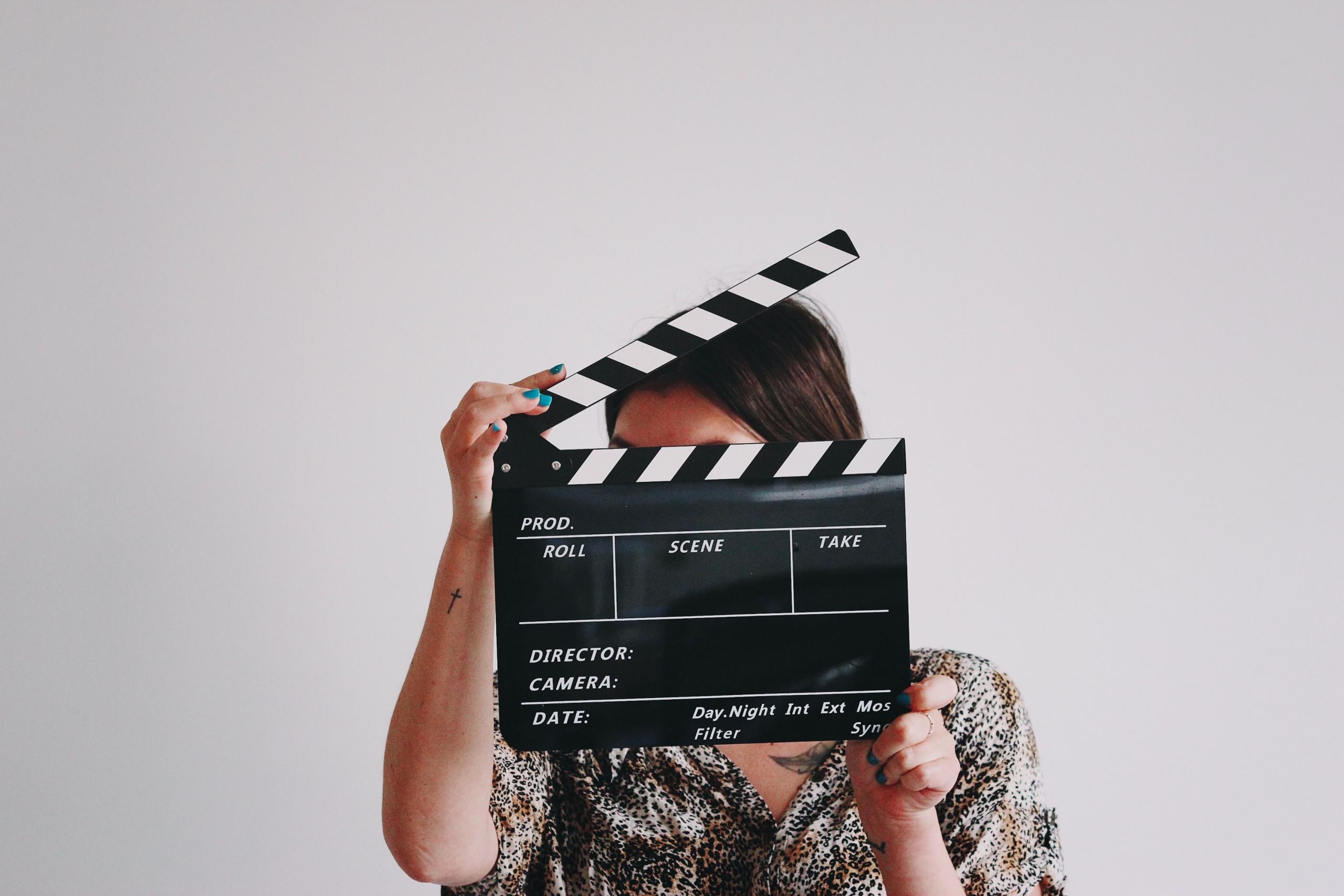 Een dame met een filmklapper bereidt iedereen voor op het begin van de scène