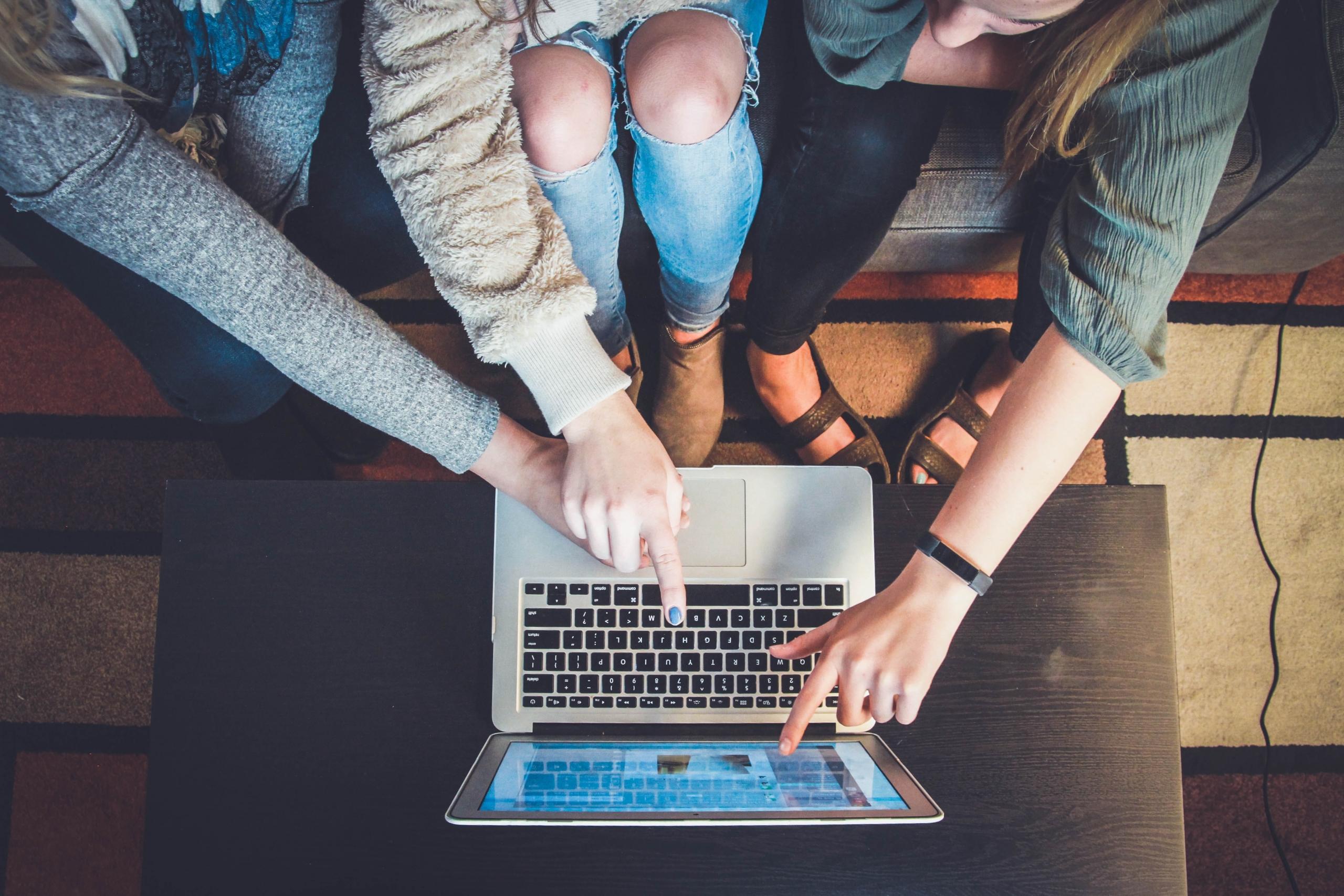 Een groep mensen kijkt samen naar een laptop