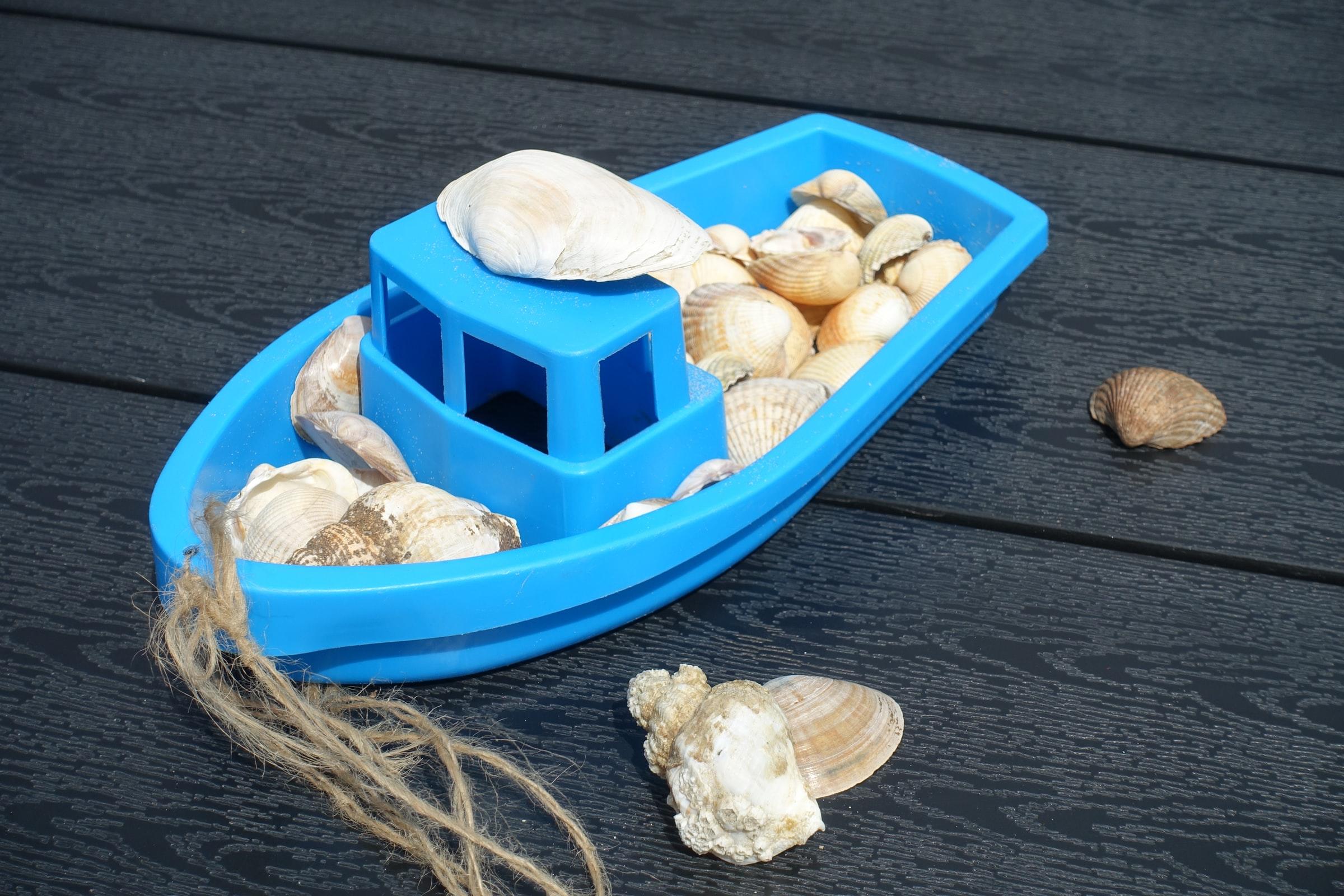 Blauw plastic speelgoed bootje met schelpen