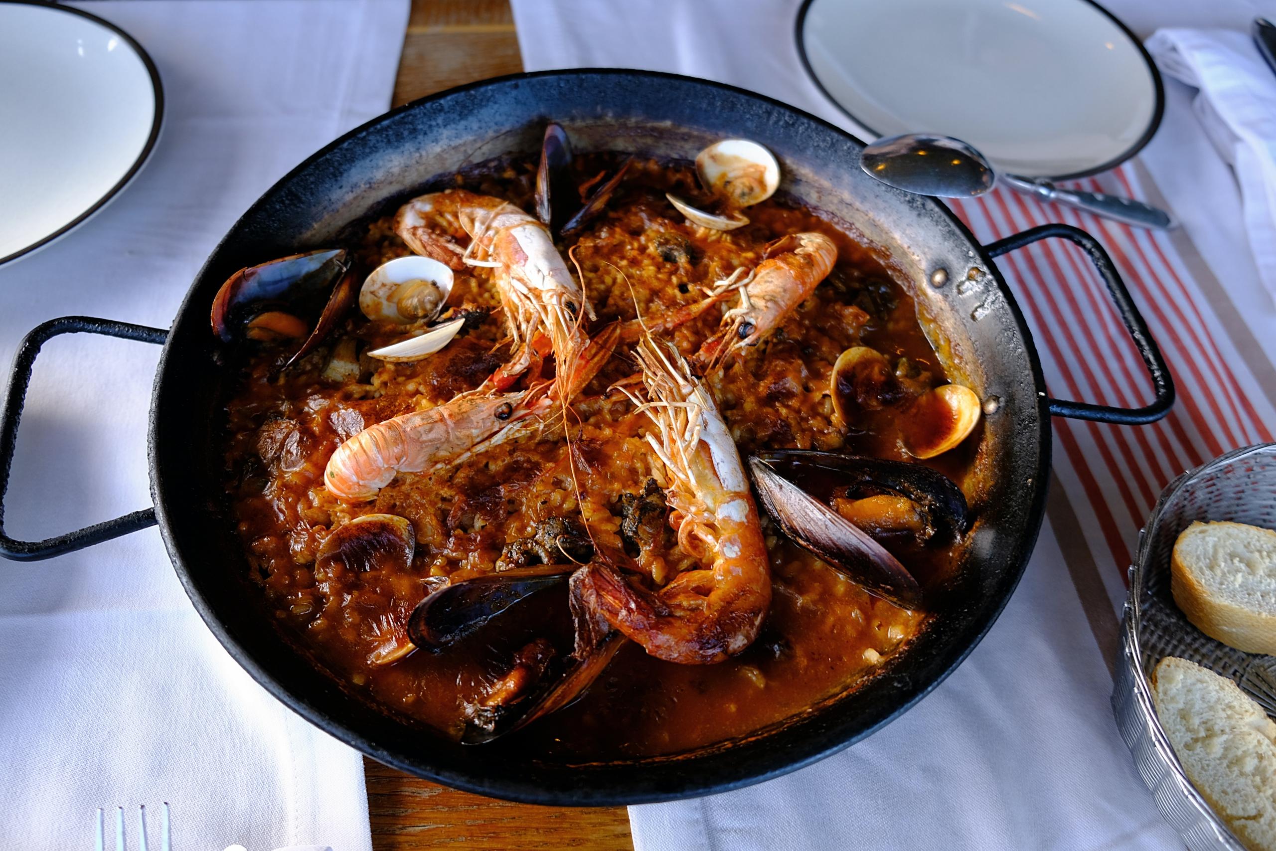 Een schotel met paella op een gedekte tafel