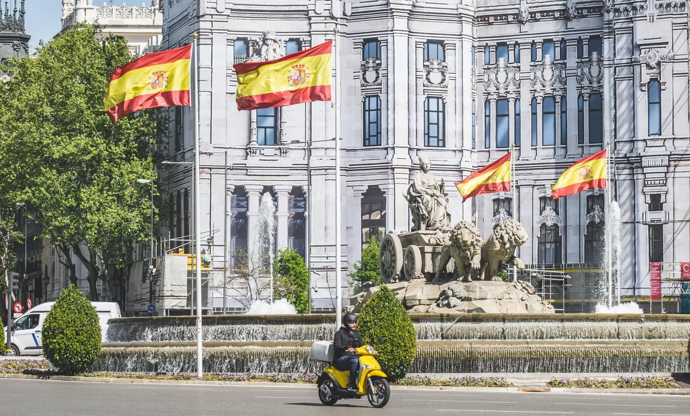 Drie Spaanse vlaggen in een straat.