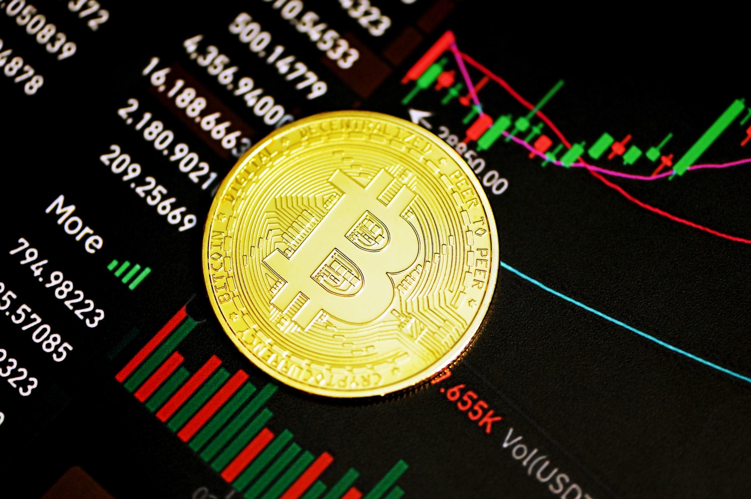 Een bitcoin bovenop een handelsgrafiek