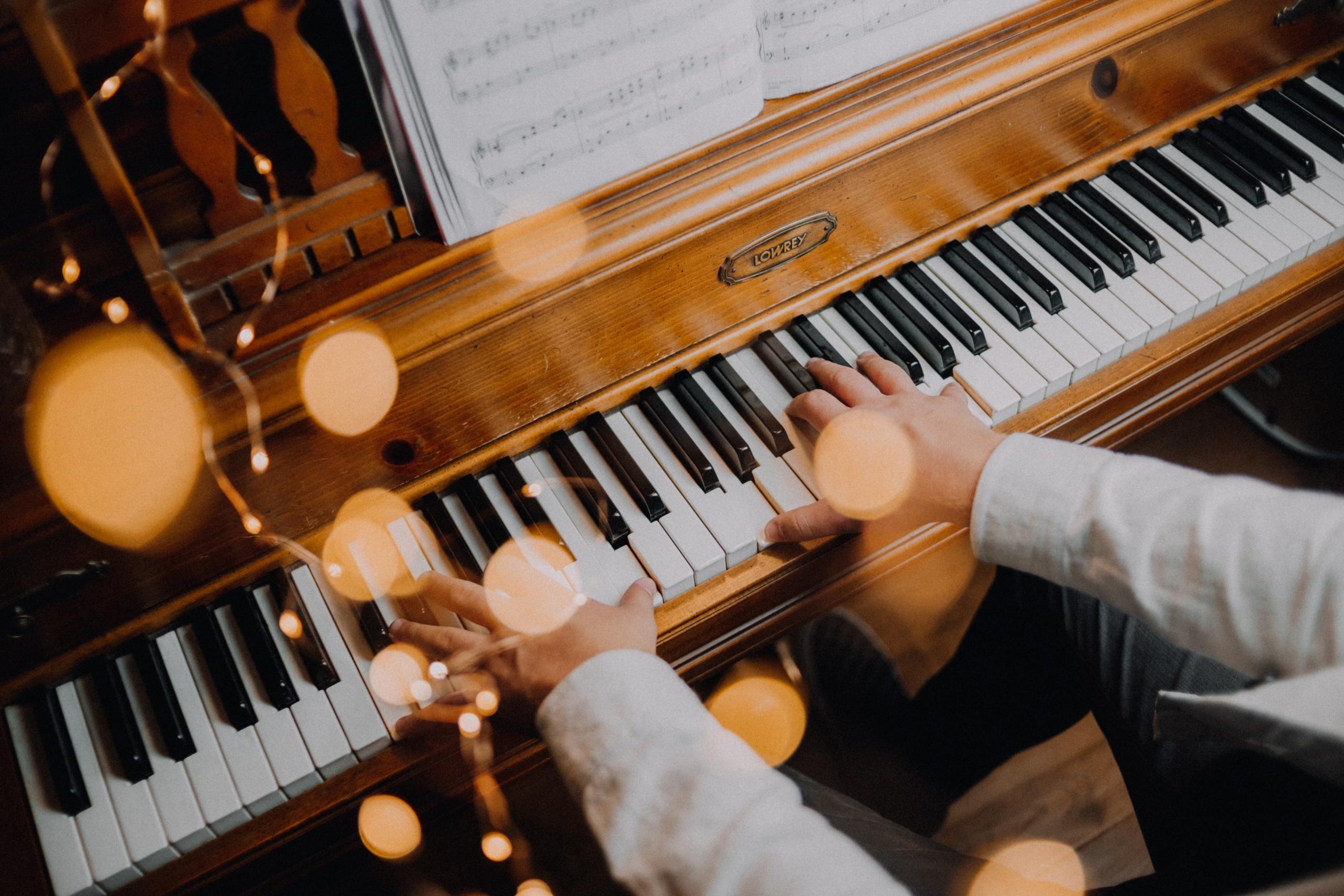 Twee handen op het klavier van een piano