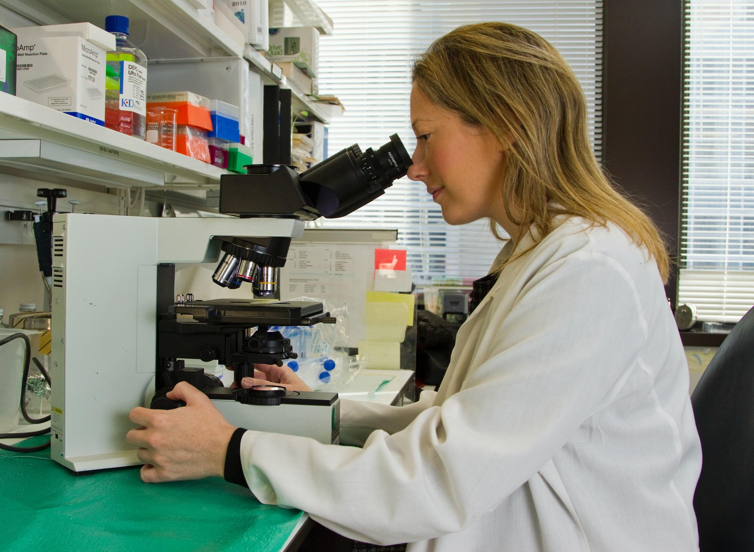 Onderzoeker kijkt in een microscoop