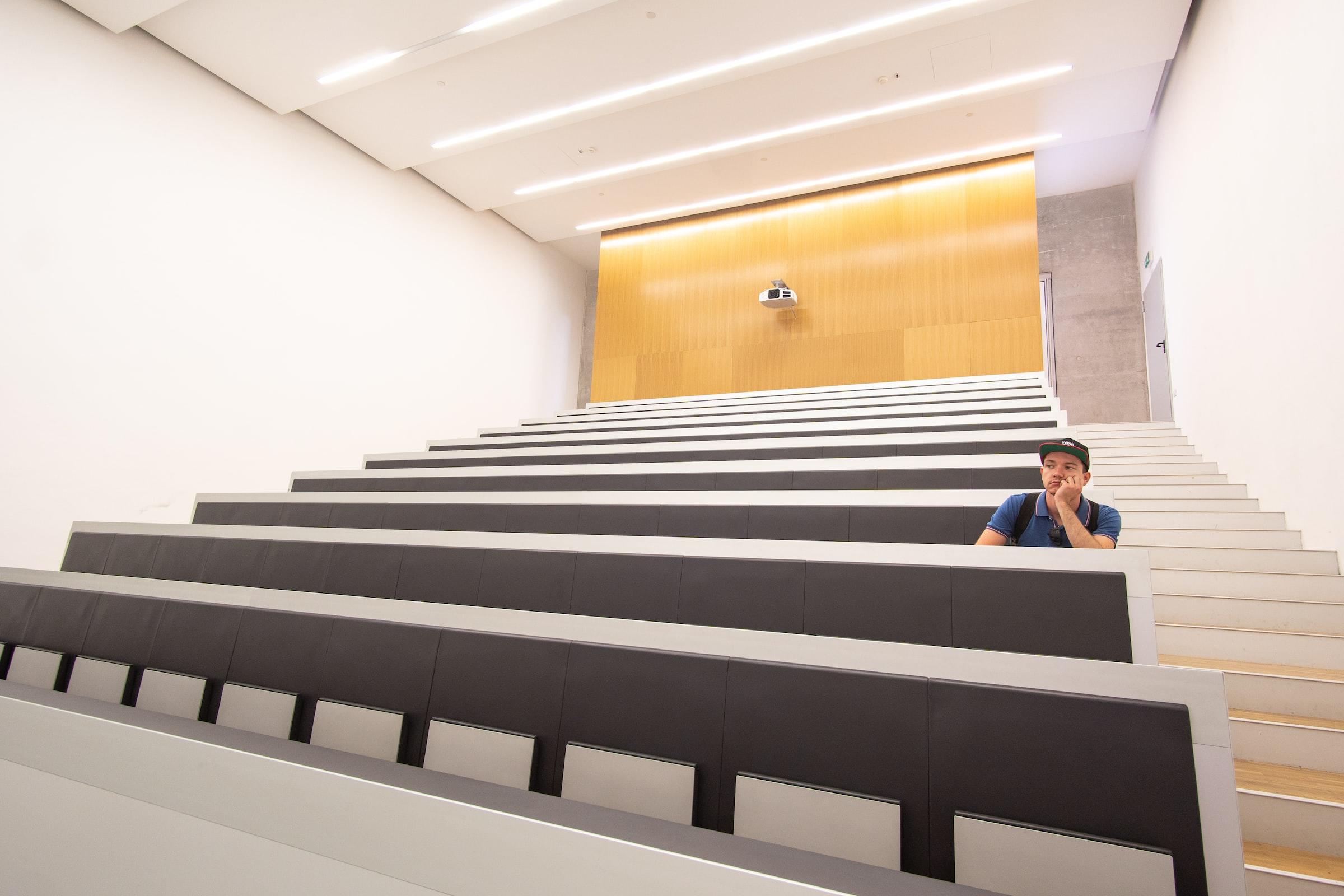 Denkende man in lege collegezaal in Milaan