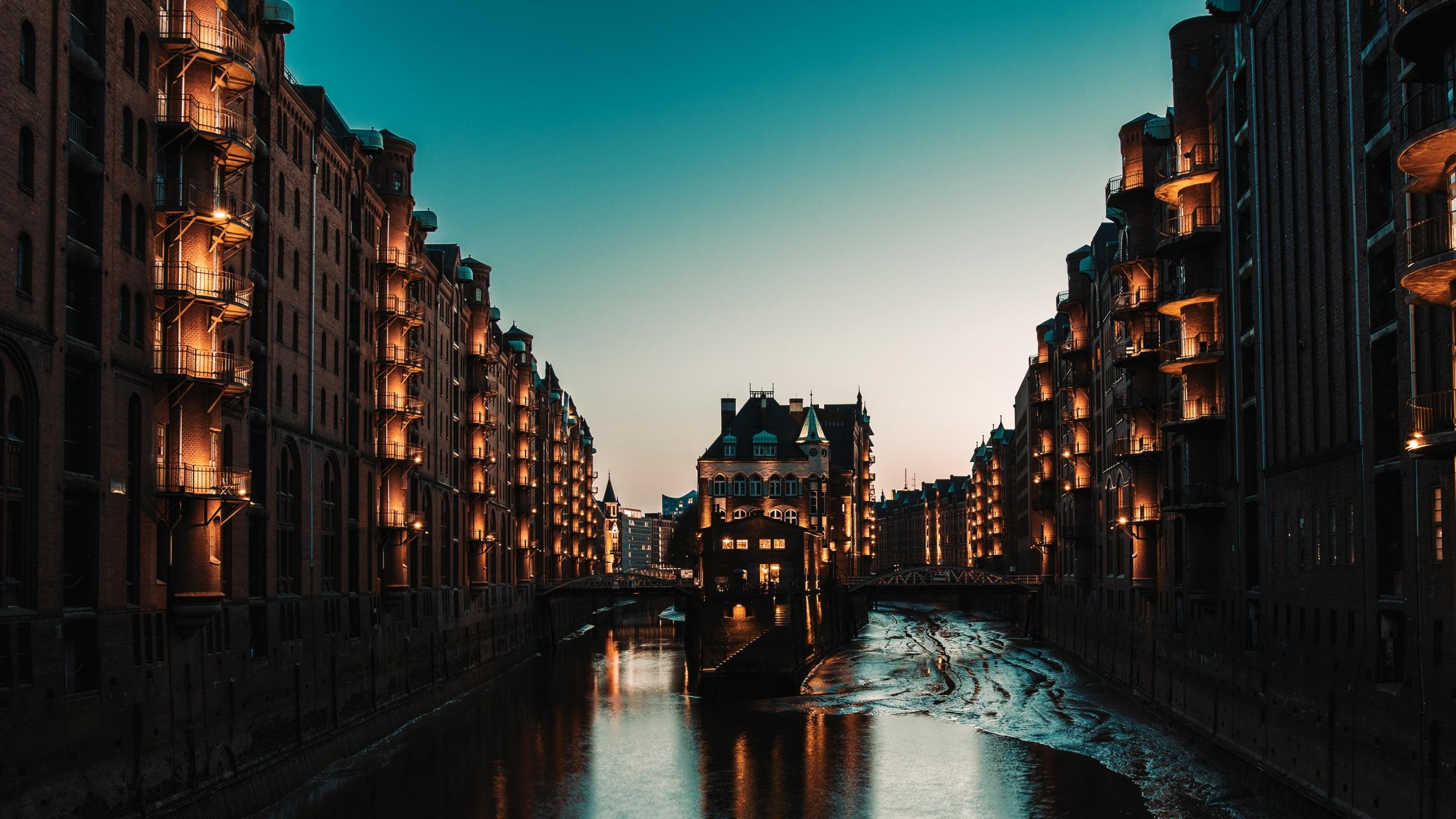 Gebouwen rond een gracht in de avond verlicht
