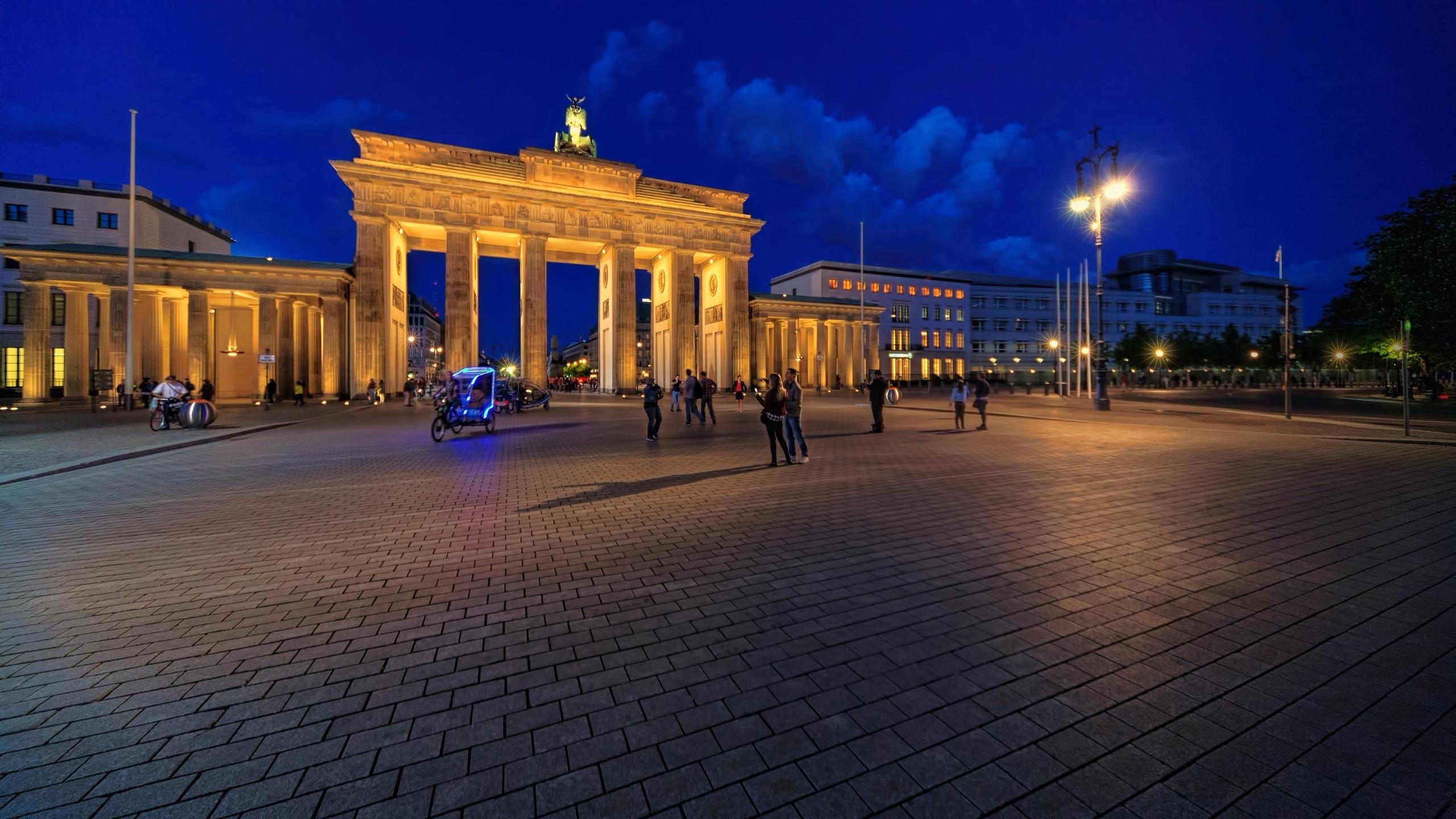 Plein met verlicht monument en mensen
