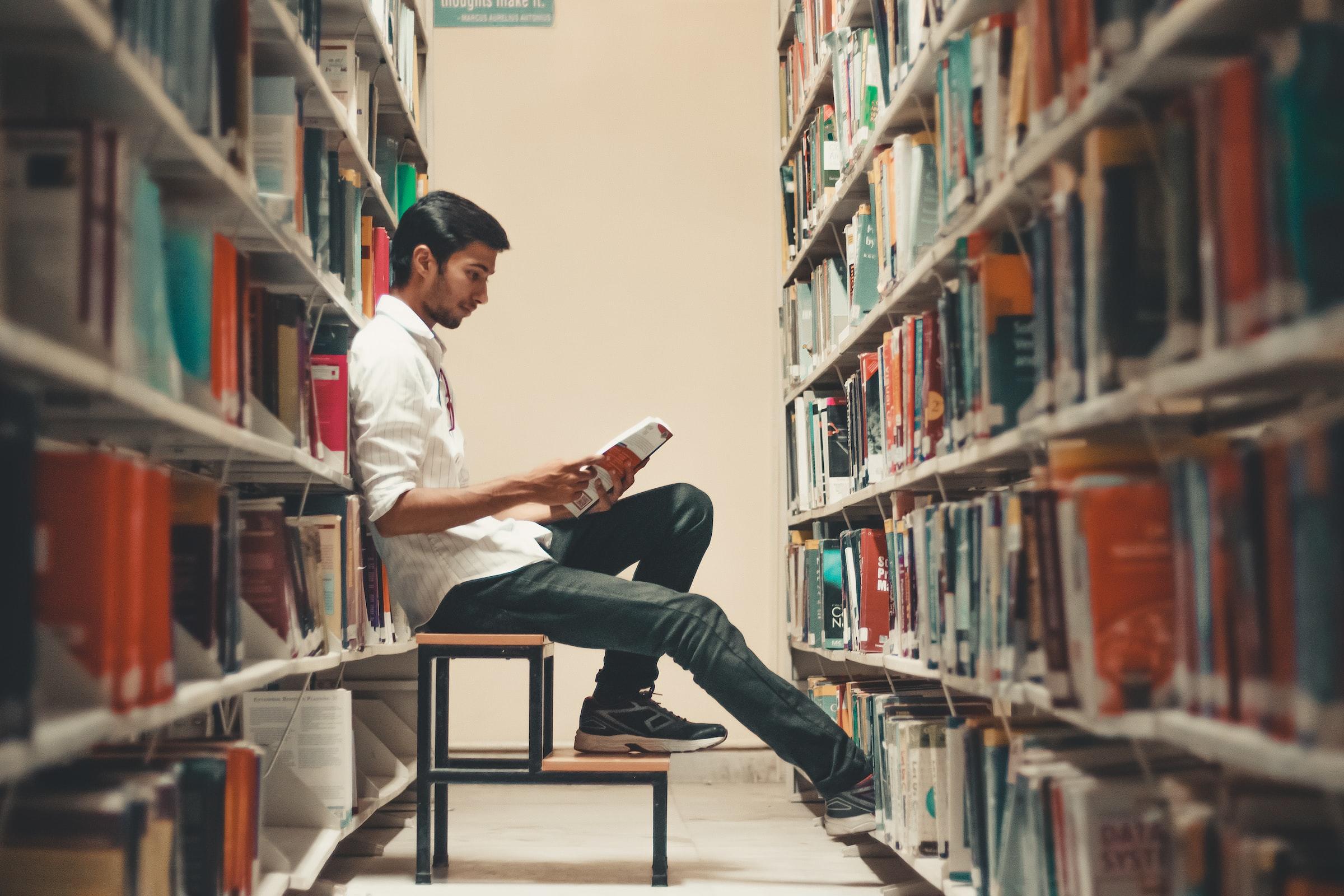 Een lezende persoon in de bibliotheek