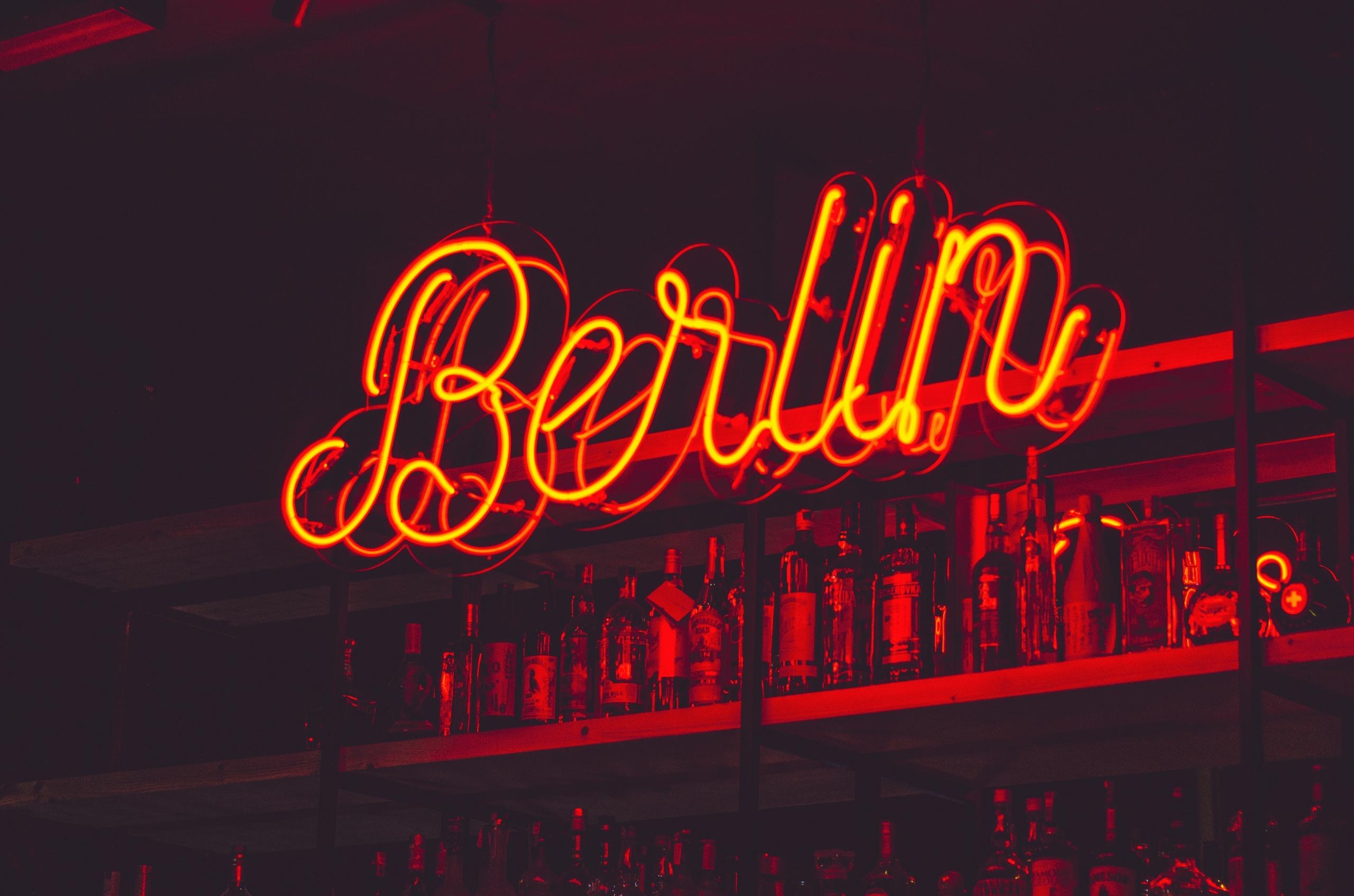 Berlin in neonverlichting met flessen erachter