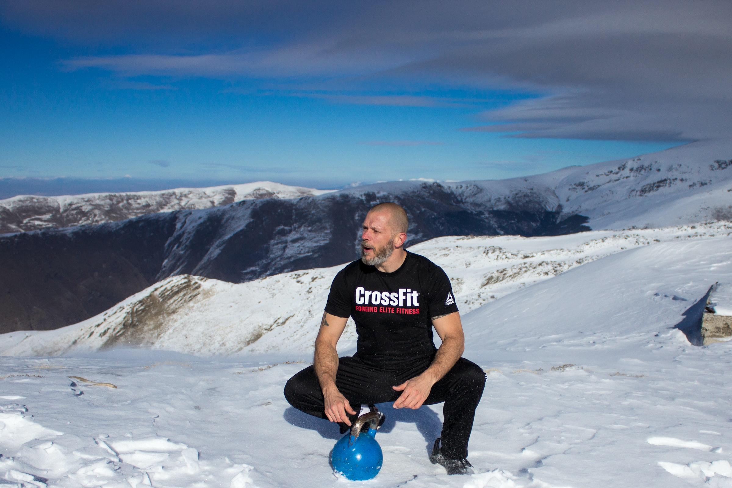 CrossFit man in de sneeuw met een kettlebell